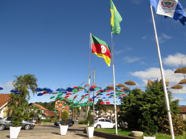 Praça de Canela decorada com guarda-chuvas coloridos além das bandeiras